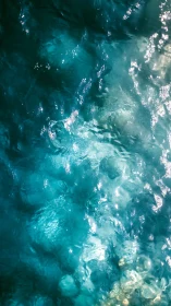 Sunlit turquoise ripples dancing across clear ocean water.