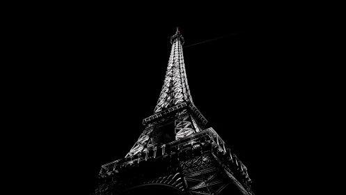 Illuminated Eiffel Tower structure viewed from low vantage point