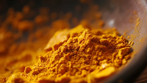 Close-up macro view of ground yellow spice powder in bowl.