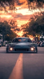 Lowered sports car centered on street at warm sunset sky