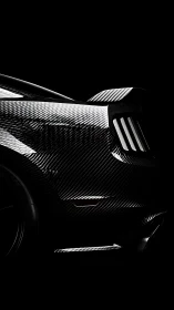 Rear carbon fiber sports car body in low key lighting.