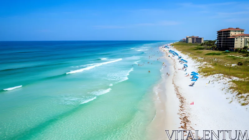 Emerald shoreline and white sand beach stretch into distance.