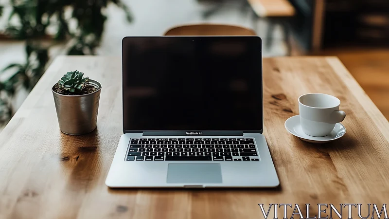 Cozy wooden desk with laptop, coffee cup, and small plant.