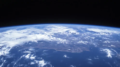 Curved Earth horizon viewed from space with cloud-covered land