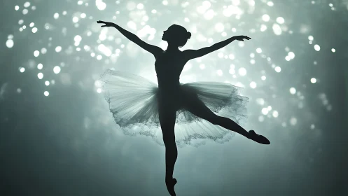 Silhouette of ballet dancer against defocused stage lights.
