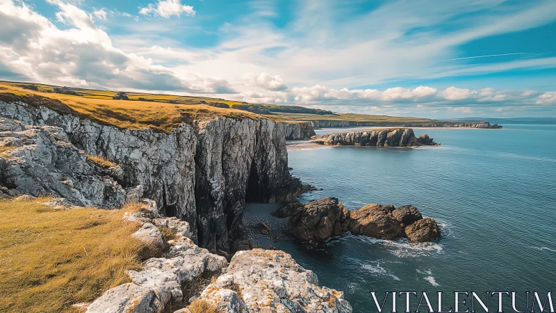 Coastal cliffs meet open sea under partly cloudy skies