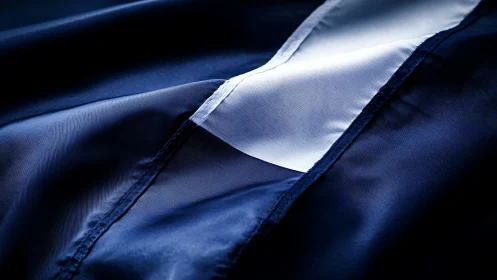 Navy fabric folds reveal sharp white diagonal stripe detail