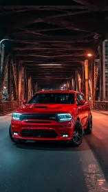 Red performance SUV dominates moody urban steel bridge night