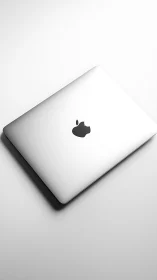 Silver laptop dozes in soft light like a minimalist moon