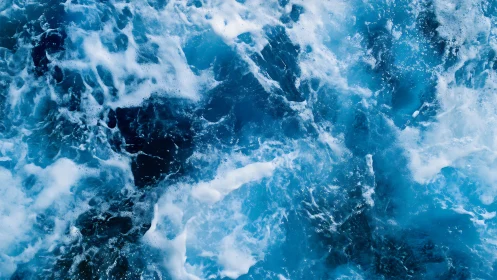 Churning blue ocean water with strong white sea foam.