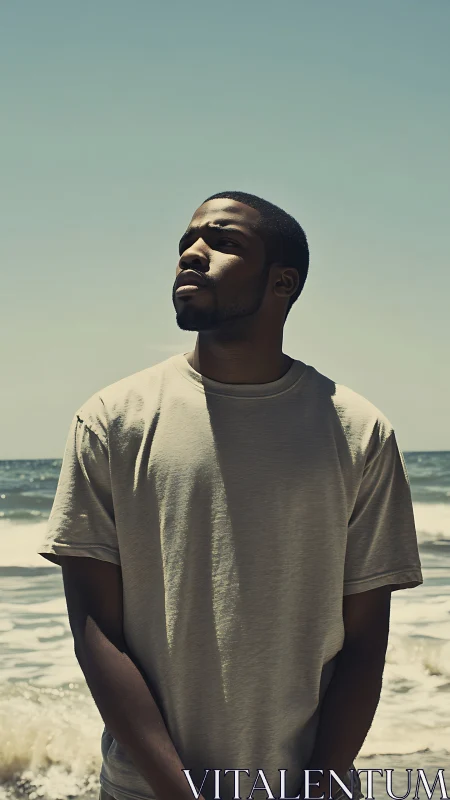 Man stands oceanside in hard midday sun, gaze upward.
