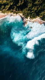 Aerial coastal surf impact on rocky shoreline and forest margin