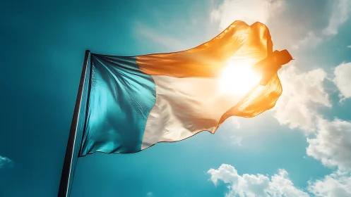 Tricolour flag with teal, white, orange against sky.