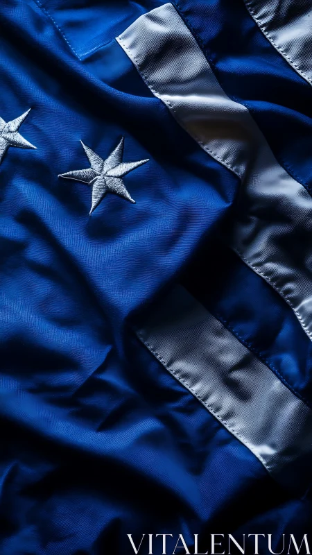 Crumpled blue flag with embroidered stars under directional light