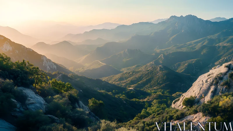 Morning haze over layered mountain ridges at sunrise.