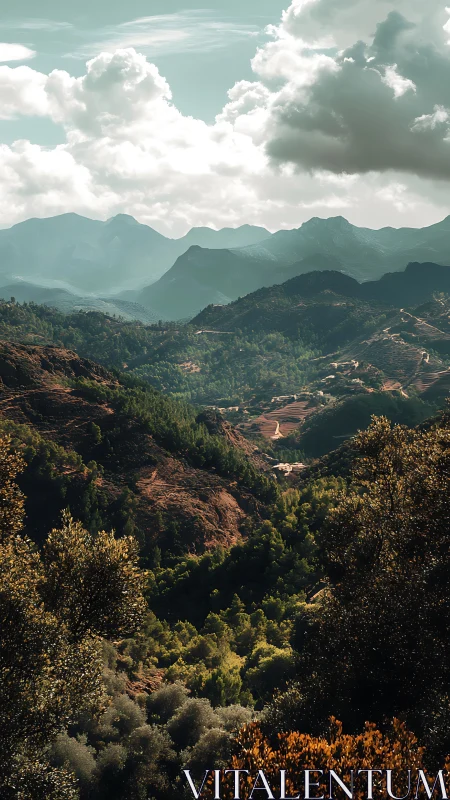 Mountain valley landscape shows layered ridges and clouds