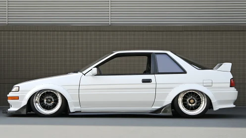 Stanced white 1980s coupe with widebody aero and deep dish wheels.