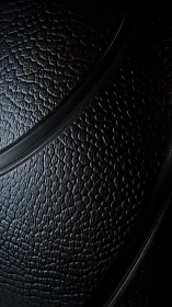 Close view of textured black surface with curved seams.