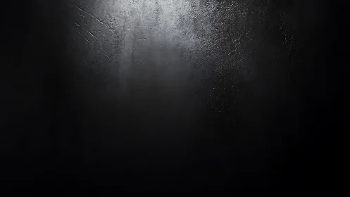 Dark textured surface with central light gradient illumination.