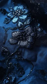 Midnight blue floral embroidery shimmers on sheer fabric.