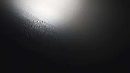 Diagonal gradient light across dark textured surface plane.