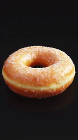 Glazed sugar donut rests against deep black background.