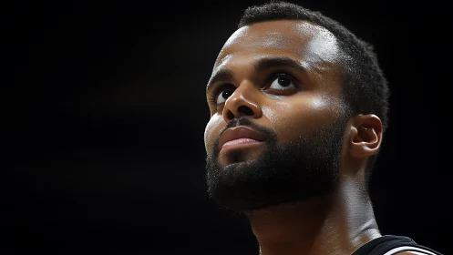 Focused basketball player under dramatic arena lighting.