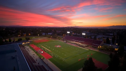 Aerial view of illuminated football stadium at sunset.