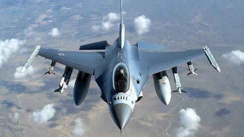 Steel falcon knifes through desert sky above wandering clouds.