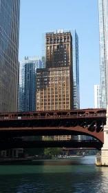 Steel bridge over river with aligned urban skyscrapers.