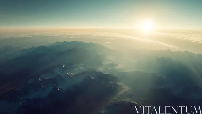 Sunlit mountain range emerges through misty atmospheric haze