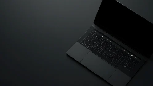 Matte black laptop in minimal overhead studio lighting setup.