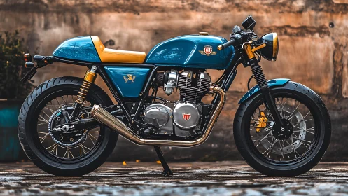 Retro cafe racer motorcycle in teal and gold livery profile.