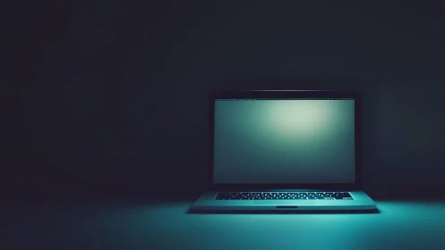 Minimal laptop screen glows in dark teal negative space.