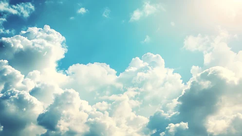 Sunlit cumulus clouds fill vibrant cyan summer sky.