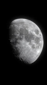 Crisp lunar crescent reveals cratered surface in deep space.