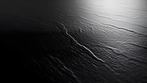 Close-up of dark textured slate surface in dramatic lighting.