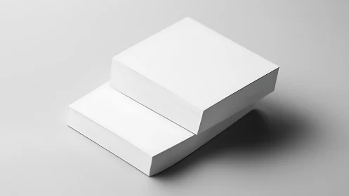 Minimalist stacks of blank white paper rest on gray surface.