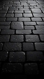 Wet cobblestone pavement under moody low sidelighting.