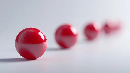 Glossy red spheres aligned on light gradient surface.