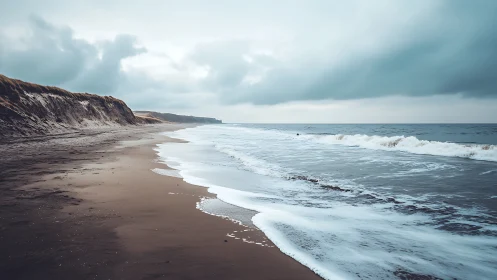 Stormy shoreline curves beneath brooding grey skies.