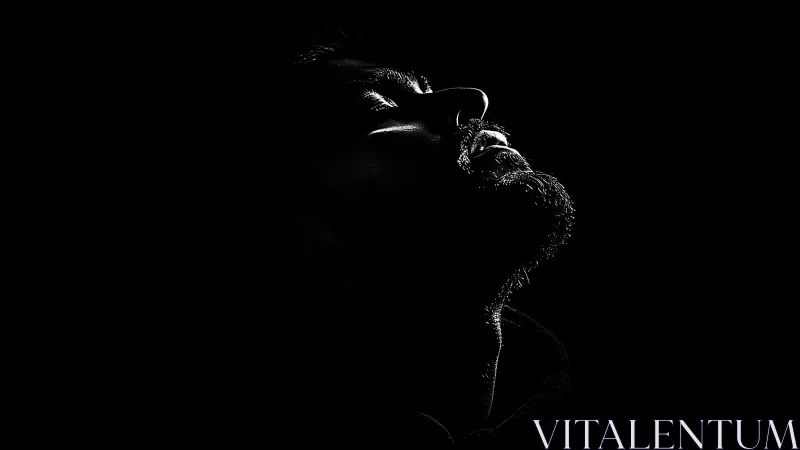 Low key male portrait in stark profile with rim lighting.