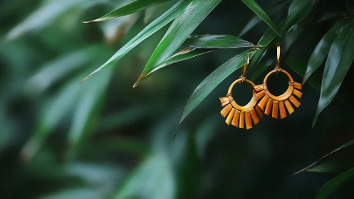 Golden hoop earrings glowing gently in lush green leaves.