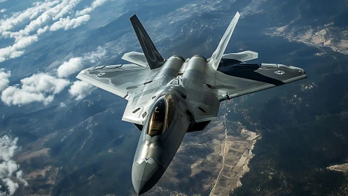 Stealth fighter jet cruising above mountainous landscape