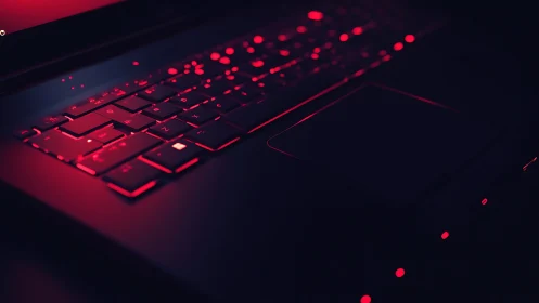 Backlit laptop keyboard in low key red cyberpunk illumination