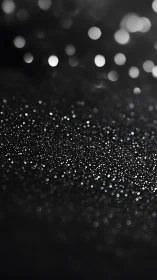 Black background with scattered silver glitter bokeh glow.