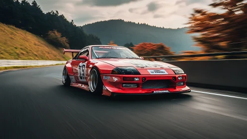 Red time-attack race car corners on autumn mountain circuit.