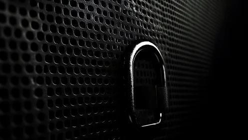 Textured black metal grille with single chrome loop detail.