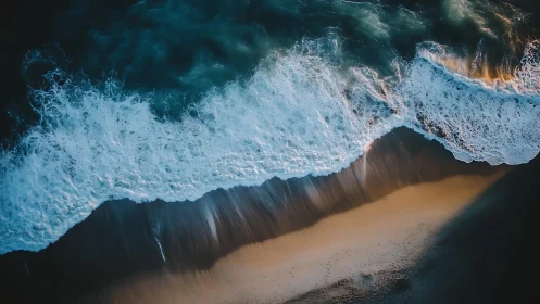 Rolling ocean surf washes over sunlit empty shoreline.