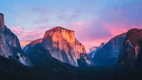 Sunlit granite cliffs glow beneath vibrant pink sunset clouds.